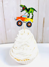 Load image into Gallery viewer, Monster jam inspired monster trucks with a T-Rex dinosaur cupcake toppers. Each monster truck features a T-Rex standing on the back of the truck. The monster truck dinosaur cupcake toppers are professionally printed, cut and attached to four inch bamboo skewers. The monster truck dinosaur cupcake toppers are handcrafted in the USA. The truck options are Grave Digger, Megaladon, El Toro Loco, Tornado and Dragon.