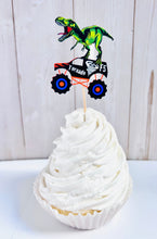 Load image into Gallery viewer, Monster jam inspired monster trucks with a T-Rex dinosaur cupcake toppers. Each monster truck features a T-Rex standing on the back of the truck. The monster truck dinosaur cupcake toppers are professionally printed, cut and attached to four inch bamboo skewers. The monster truck dinosaur cupcake toppers are handcrafted in the USA. The truck options are Grave Digger, Megaladon, El Toro Loco, Tornado and Dragon.