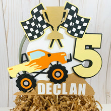 Load image into Gallery viewer, Monster Jam inspired monster truck cake topper. The cake topper features a monster jam inspired monster truck on a dirt mound, a checkered flag, tropy and number. The cake topper is also personalizable with your child's name. The truck options are Grave Digger, Megaladon, El Toro Loco, Tornado and Dragon.