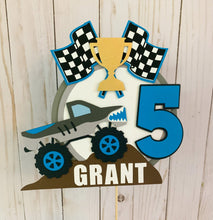 Load image into Gallery viewer, Monster Jam inspired monster truck cake topper. The cake topper features a monster jam inspired monster truck on a dirt mound, a checkered flag, tropy and number. The cake topper is also personalizable with your child's name. The truck options are Grave Digger, Megaladon, El Toro Loco, Tornado and Dragon.