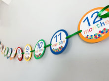 Load image into Gallery viewer, Designed and handcrafted by Declan & Smith Party Decor, this It's a ball to be one first birthday photo banner is the perfect addition to your little one's birthday party! Featuring a ball pit on each month, 13 months, newborn - 12 months and mini clothespin for easily hanging your photos, this banner is fully customizable to perfectly fit your party decor scheme.