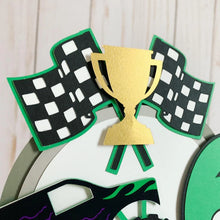 Load image into Gallery viewer, Monster Jam inspired monster truck cake topper. The cake topper features a monster jam inspired monster truck on a dirt mound, a checkered flag, tropy and number. The cake topper is also personalizable with your child's name. The truck options are Grave Digger, Megaladon, El Toro Loco, Tornado and Dragon.
