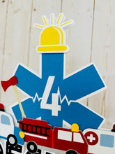 Load image into Gallery viewer, The first responders cake topper features a police car, firetruck, ambulance, road letters, EMT emblem with age and heart beat monitor with a yellow siren.