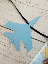 Load image into Gallery viewer, Top Gun fighter jet themed first birthday photo banner. The top gun photo banner features two fighter jets flanking 13 white clouds. The clouds are numbered NB - 12 months for a first birthday. The numbers can be customized to fit any age birthday. The planes, number colors and ribbon color is customizable.