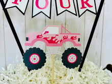 Load image into Gallery viewer, Pink monster truck cake topper. The cake topper is customizable and can display an age, name, word or phrase. The colors are also customizable. The pink monster truck cake topper features two checkered flags, pennant banner and a monster truck to display underneath the bunting. The pink monster truck cake topper is designed and handcrafted by Laura, the owner of Declan & Smith Party Decor.