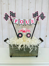 Load image into Gallery viewer, Pink monster truck cake topper. The cake topper is customizable and can display an age, name, word or phrase. The colors are also customizable. The pink monster truck cake topper features two checkered flags, pennant banner and a monster truck to display underneath the bunting. The pink monster truck cake topper is designed and handcrafted by Laura, the owner of Declan & Smith Party Decor.