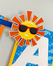 Load image into Gallery viewer, Waterslide summer happy birthday banner featuring fun summer elements that include ice cream, water guns, water balloons, umbrellas, sunglasses, beach chairs, beach balls and a waterslide.