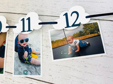 Load image into Gallery viewer, Top Gun fighter jet themed first birthday photo banner. The top gun photo banner features two fighter jets flanking 13 white clouds. The clouds are numbered NB - 12 months for a first birthday. The numbers can be customized to fit any age birthday. The planes, number colors and ribbon color is customizable.