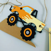 Load image into Gallery viewer, Monster Jam inspired monster truck happy birthday banner. The banner features monster jam logo inspired triangle pennants, a checkered flag, Grave Digger, Megladon, Tornado, El Toro Loco and Dragon monster trucks.