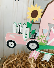 Load image into Gallery viewer, The pink barnyard farm animals cake topper features a pink barn, pink tractor, white picket fence, farm animals and a pink and light blue pennant banner to display your little one's name.