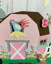 Load image into Gallery viewer, The pink barnyard farm animals cake topper features a pink barn, pink tractor, white picket fence, farm animals and a pink and light blue pennant banner to display your little one's name.
