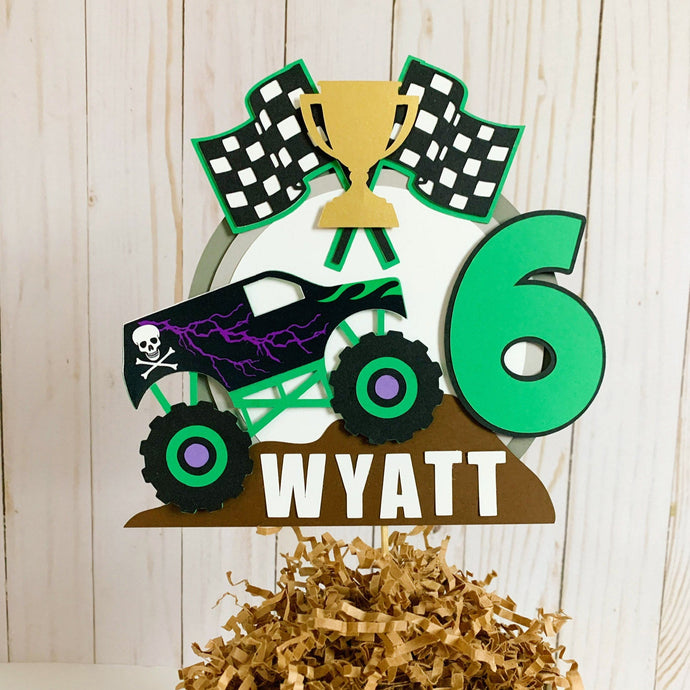 Monster Jam inspired monster truck cake topper. The cake topper features a monster jam inspired monster truck on a dirt mound, a checkered flag, tropy and number. The cake topper is also personalizable with your child's name. The truck options are Grave Digger, Megaladon, El Toro Loco, Tornado and Dragon. 