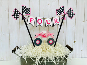 Pink monster truck cake topper. The cake topper is customizable and can display an age, name, word or phrase. The colors are also customizable. The pink monster truck cake topper features two checkered flags, pennant banner and a monster truck to display underneath the bunting. The pink monster truck cake topper is designed and handcrafted by Laura, the owner of Declan & Smith Party Decor. 