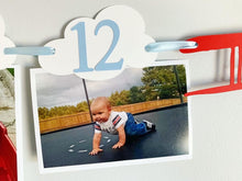 Load image into Gallery viewer, Airplane time flies birthday decorations. Vintage biplane first birthday monthly milestones photo banner featuring white clouds, number NB - 12. 
